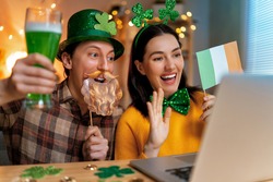 Happy family couple celebrating St. Patrick's Day with their friends by online at home.