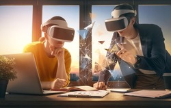 Metaverse technology concept. Man and woman with VR virtual reality goggles are working in the office. Futuristic lifestyle.