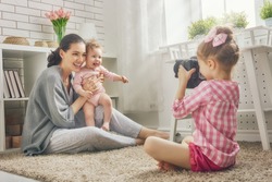 Happy loving family. Mother and her daughters children girls playing and making photo.