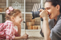 Happy loving family. Mother and her daughter child girl playing and making photo.