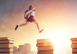 Back to school! Happy cute industrious child running and jumping on books on background of sunset urban landscape. Concept of education and reading. The development of the imagination.