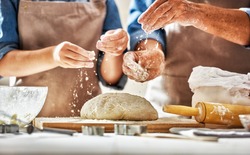 Close up view of bakers are working. Homemade bread. Hands preparing dough on wooden table. 