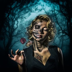 Portrait of a retro woman with skull make-up and dried flowers in her hand in the night forest