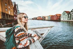 Young blonde woman traveling in Trondheim city Norway vacations weekend Lifestyle outdoor girl tourist with backpack sightseeing scandinavian architecture alone