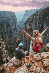 Couple on cliff Tazi canyon travel hiking together healthy lifestyle active summer vacations outdoor young man and woman tourists enjoying aerial view exploring Turkey