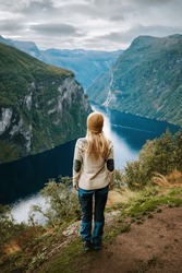 Woman tourist hiking in Norway alone sightseeing Geiranger fjord landscape adventure active lifestyle vacations sustainable tourism scandinavian tour 