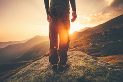 Young Man Traveler feet standing alone with sunset mountains on background Lifestyle Travel concept outdoor 