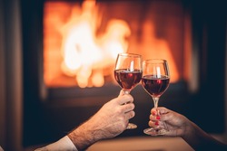 glasses of red wine and romantic fireplace