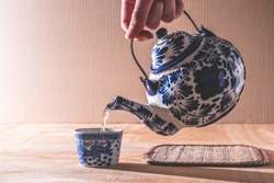 Close up of Male hand pouring tea from chinese teapot