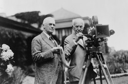 Thomas Edison 1847-1931 and George Eastman 1854-1932 standing with motion picture camera ca. 1925.