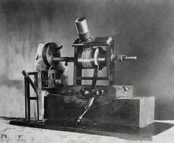 Edison's First Movie Machine, the Kinetoscope, was a 'Talkie'. In 1886 the clockwork turned one shaft causing the small pictures to seem to move when viewed through the magnifying glass. Simultaneousl