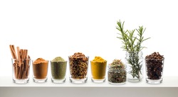 glass jars with various spices on white shelf