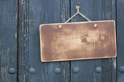 Wooden signboard with rope hanging on planks background