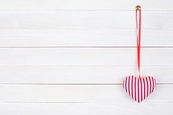Valentine love heart hanging on vintage white wood background
