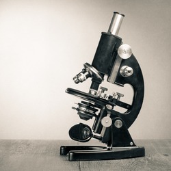 Old vintage microscope on table sepia photo
