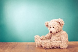 Teddy Bear toy alone on wood in front mint green background