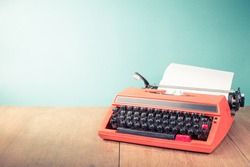 Retro old typewriter with paper sheet on wooden table front mint green background. Vintage style filtered photo