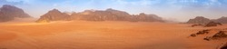 Panorama wide angle of an empty Wadi Rum desert in spring, with some clouds in the air. 