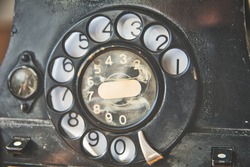Close-up of turning wheel of old-fashioned vintage rotary phone. Retro technology
