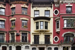 Colorful New York townhouse facades with ornate cornice moldings