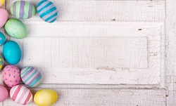 Easter eggs painted in pastel colors on a white cracked antique background