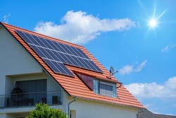 An image of a home with solar energy green plants and sunny blue sky