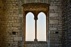 Medieval mullioned window with countryside at the horizon