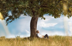 Human sitting under tree. Man repose on grass in nature. Outdoors - outside. No stress, carefree
