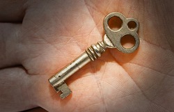 an ancient small key laying on a palm