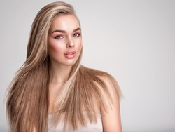 Portrait of a blonde beautiful woman with a long straight light hair. Portrait of a beautiful woman with a coral color makeup. Girl with  bright fashion make-up. Beautiful female face. Fashion model.