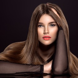 Woman with beauty long brown hair. Fashion model with long straight hair. Fashion model with a smokey makeup. Pretty woman with orange color lipstick on lips. 
