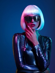 Stylish blonde in shiny dress and sunglasses with stresses. Closeup face  of beautiful  fashionable woman in white wig. Art portrait  of  an young attractive model. Fantasy style. Glamour fashion girl