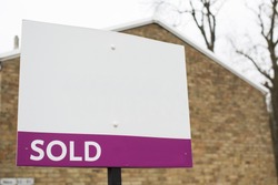 Blank SOLD sign outside a building, space for text to be added