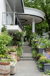exterior of the street entrance to the flower garden with stairs decorated with a variety of potted flowers