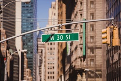 Street sign on W 30 St in New York City - Urban concept in Midtown Manhattan.