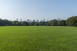 Panorama view of New York City Central Park with Manhattan skyline.