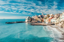 View of Bogliasco. Bogliasco is a ancient fishing village in Italy, Genoa, Liguria. Mediterranean Sea, sandy beach and architecture of Bogliasco town. Cloudy blue sky sunny day idyllic scenery, winter