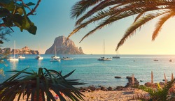 Famous, empty and beautiful Cala d'Hort beach, in summer very popular, sandy coast have a fantastic view of mysterious island of Es Vedra. Moored vessels on bay. Ibiza Island, Balearic Islands. Spain