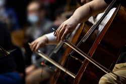  Hands of a musician playing cello in an orchestra