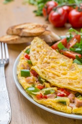 Delicious Egg Omelet with Ham and Vegetables on the Plate