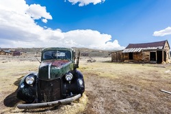 Wreck of a ancient rusty car in a ghost town of Bodie. Bodie is a National Historic Landmark. It is located in Mono County, Sierra Nevada - California. United States of America. 