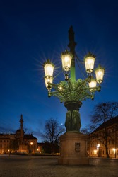 Historic gas street lamp on a Castle square in Prague, Czech Republic. Beautiful ornamental candelabra with 8 arms, technical monument made of cast iron in 1876