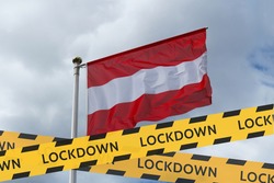 The flag of Austria against the sky and a protective tape with the inscription lockdown. Concept - Austria is quarantined due to the coronavirus epidemic.