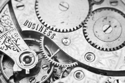 Background with the inscription BUSINESS. Black white background with metal cogwheels clockwork. Macro. Conceptual photo for your successful business design. Concept teamwork