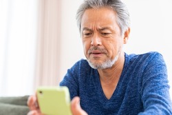 Asian elderly man who uses smart phone,think