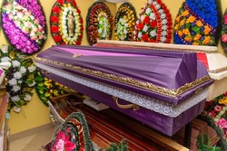 Interior of room with funeral accessories. Shop selling coffins, funeral wreaths and flowers.