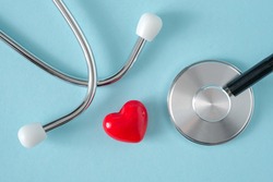 Stethoscope and heart on blue background, top view, flat lay. Heart health, health care concept. 