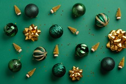 Gold Christmas tree decoration and baubles on green background. Flat lay, top view. Merry Christmas card