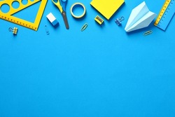 School supplies on blue background. Top view with copy space. Back to school concept.