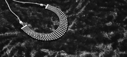 Pearls and stones silver necklace on dark black velvet background